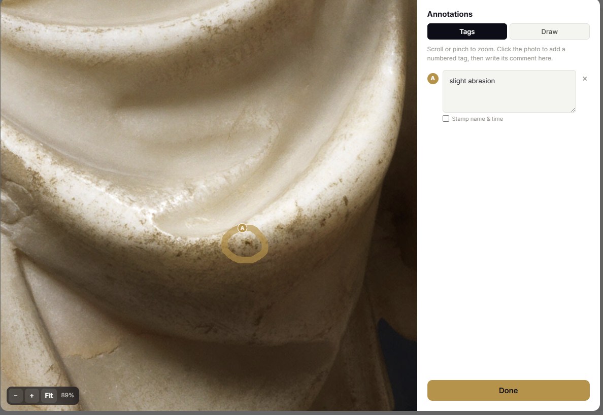 The same sculpture zoomed in close, the marble surface filling the frame, with the same tag circled and the comment 'slight abrasion'